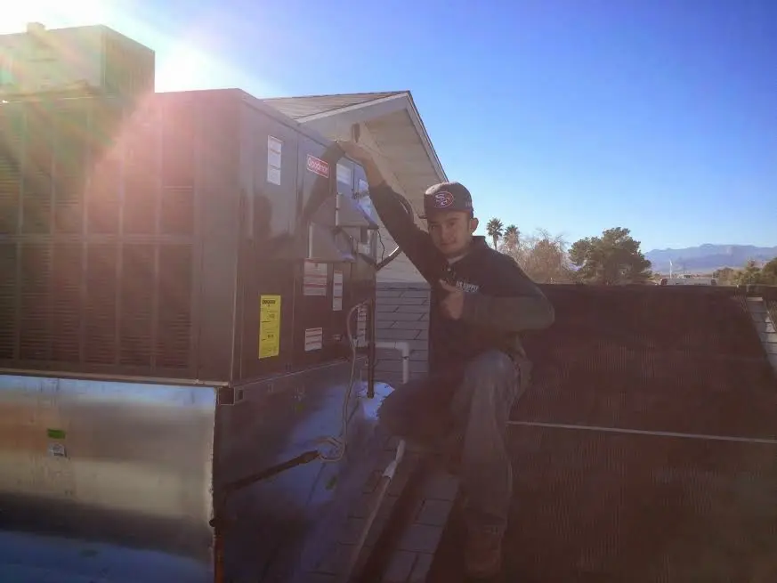 HVAC technician performing Heat Pump Repair on a rooftop unit in Marvin